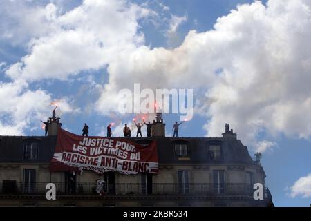 The tenants of the building of the penultimate floor tears the banner of the members of the extreme right group Generation Identitaire (GI) where it is said `` victims of anti-white racism '' during a demonstration `` Black Lives Matter '' against racism and police brutality, on the Place de la République in Paris on June 13, 2020. The banner which unfolded on the balcony below, was torn and cut by the residents of the apartment . (Photo by Mehdi Taamallah/NurPhoto) Stock Photo